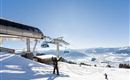 An impressive ski resort with a gondola and snow-covered slopes. The clear blue sky provides a dreamy backdrop for winter sports enthusiasts.