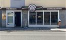 An ice cream parlor with a modern entrance and large windows. The signage displays Italian ice cream specialties.