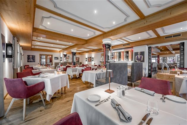 An elegant restaurant with modern furniture and stylish ambiance. The tables are carefully set and invite patrons to linger.