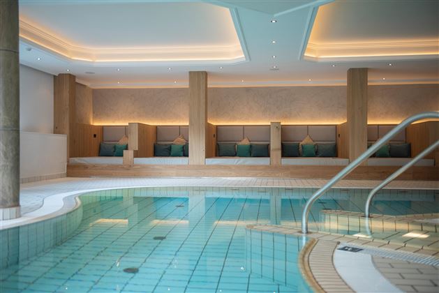 An elegant indoor pool with a bright and modern design. Relaxation areas with comfy loungers invite you to stay.