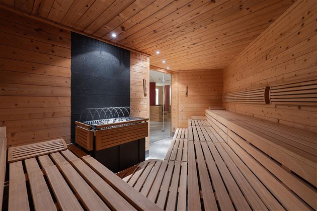 A modern sauna made of wood with a calm ambiance. The benches are evenly arranged, and the relaxing atmosphere invites you to unwind.