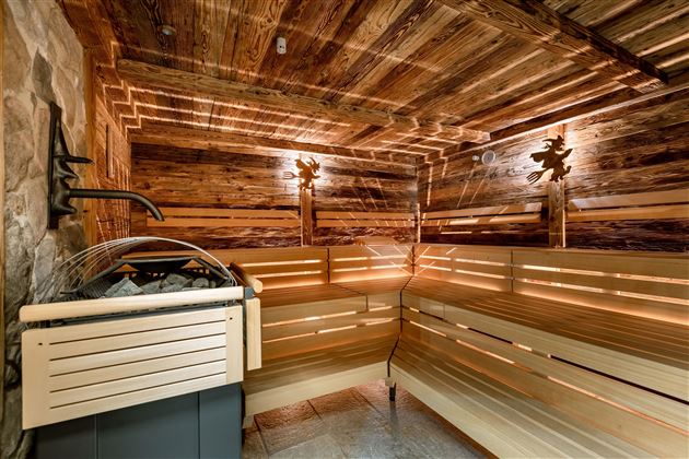 A modern sauna with wooden paneling and soft lighting. The benches provide space for relaxation and recovery.