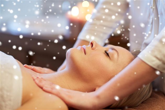 A woman receives a relaxing massage. Gentle snowflakes have a calming effect in the background.