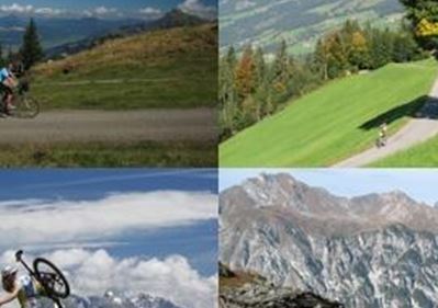 Eine malerische Berglandschaft mit Radfahrern auf verschiedenen Wegen. Klare Himmel und beeindruckende Berge zeigen die Schönheit der Natur.
