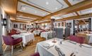 An elegant restaurant with a wooden ceiling and stylish tables. The decor is modern and inviting, ideal for a cozy meal.