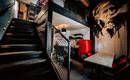 A modern, stylish interior view with a staircase and an open kitchen. An impressive mural is located on the wall.