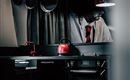 A modern kitchen with black design and red accents. On the countertop, there are pots and a red tea or coffee pot.