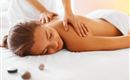 A relaxed woman is receiving a back massage. She is lying on a table and enjoying the treatment.