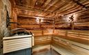 A modern sauna with wooden paneling and soft lighting. The benches provide space for relaxation and recovery.