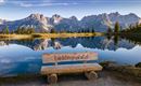 A tranquil landscape with a clear lake and majestic mountains in the background. A wooden bench with the inscription "Favorite Spot" invites you to linger.