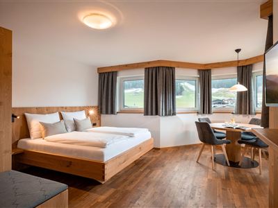 Moderní studio s manželskou postelí a útulným jídelním koutem. Prostorná okna zajišťují mnoho světla a nádherný výhled na okolní horskou krajinu.