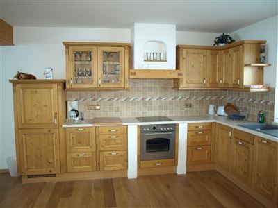 A modern kitchen made of wood with a bright and inviting design. It features a stove, cabinets, and a countertop.
