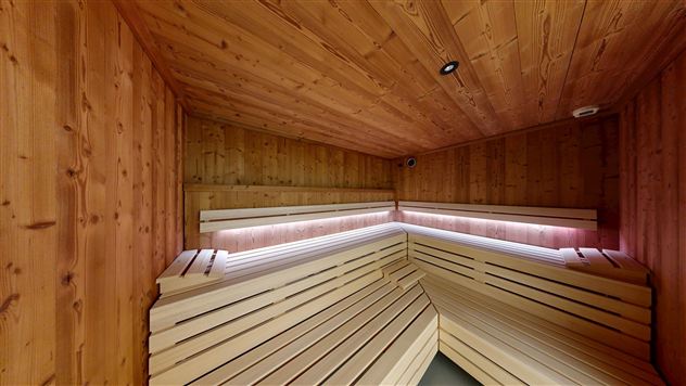A peaceful sauna with wooden walls and cozy benches. It offers a relaxing space for resting and feeling good.