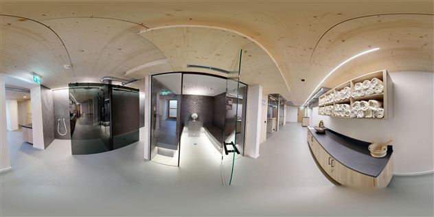 A modern space with glass shower cabins and a bright, welcoming atmosphere. On the wall, folded towels are stacked on a shelf.