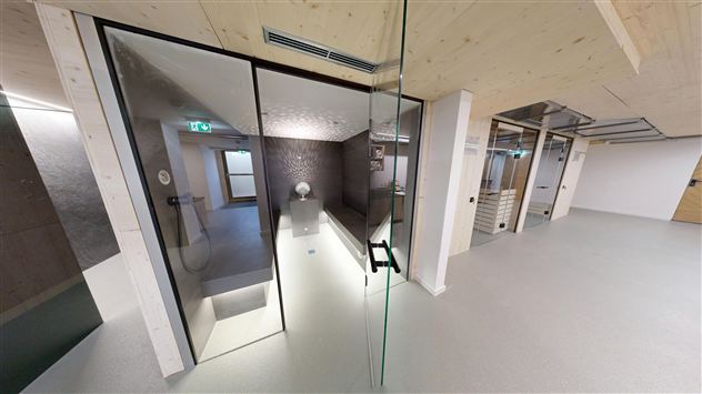 A modern room with glass walls and a minimalist design. The room is bright and open, with a touch of elegance.