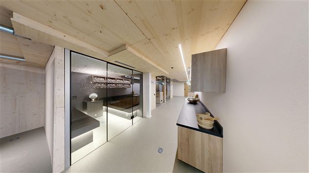 A modern room with wooden details and an elegant, minimalist design. The glass doors and simple furnishings create an inviting atmosphere.