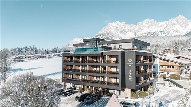 Ein modernes Hotel im Schnee mit Bergblick. Die Landschaft ist winterlich und friedlich.