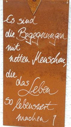 Ein rostiger Schild mit handgeschriebenem Text. Der Spruch beschreibt die Bedeutung von Begegnungen mit netten Menschen im Leben.