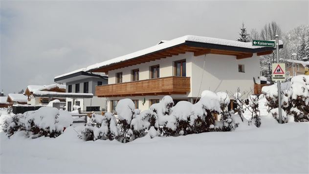 A snow-covered house in an idyllic winter landscape. Surrounded by snow and trees, the scene radiates serenity and coziness.