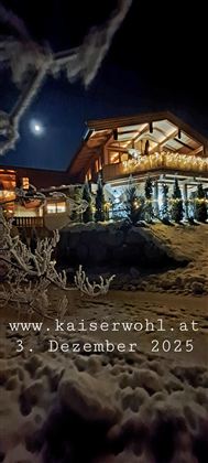 Ein gemütliches, beleuchtetes Chalet im Winter, umgeben von Schnee. Der Mond scheint hell über dem Gebäude.