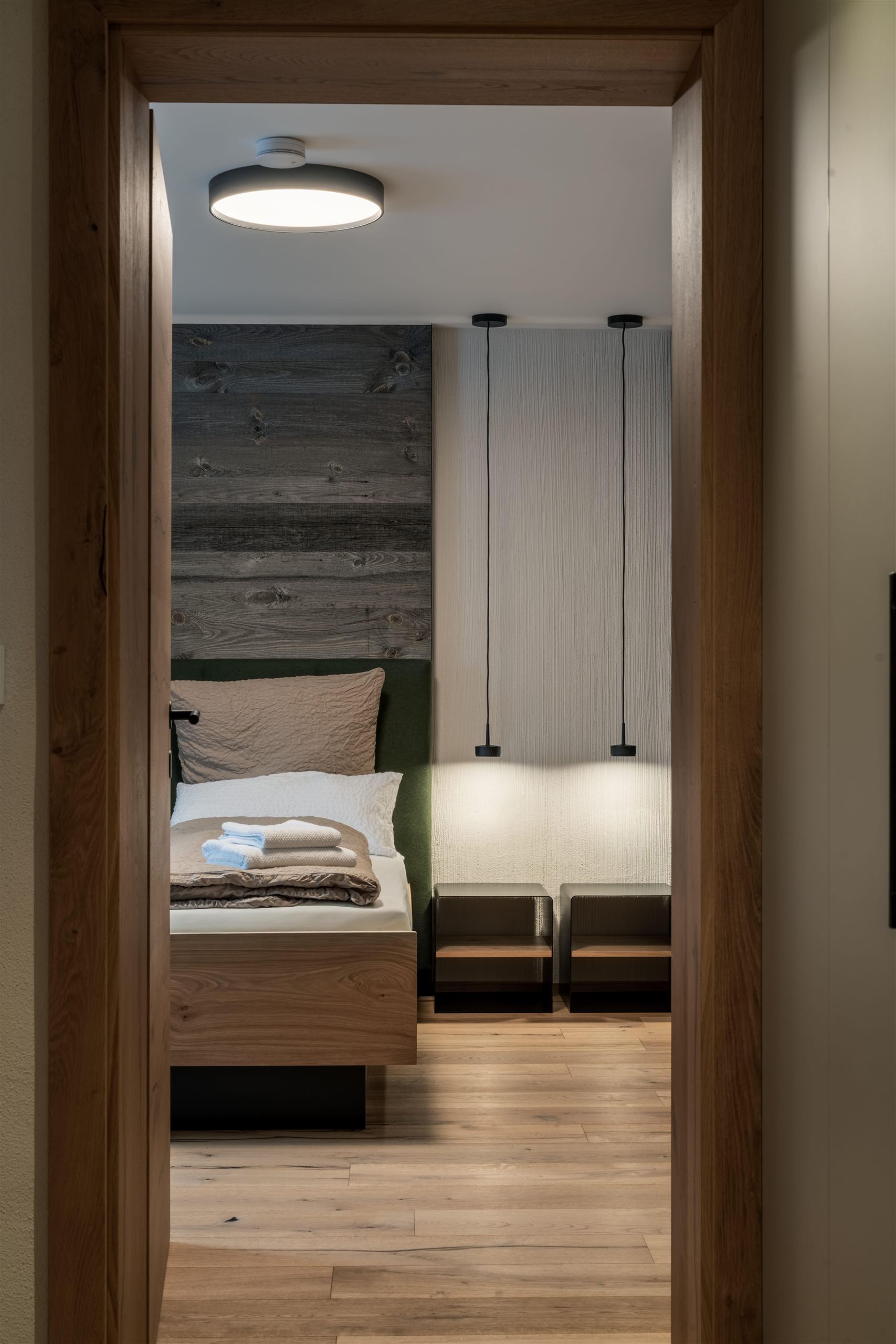 A modern bathroom with an elegant glass shower and a towel warmer. The space is bright and designed in a minimalist style.