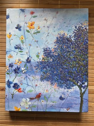 Een kleurrijk schilderij met blauwe en paarse bloemen en een boom aan de linkerkant. De achtergrond is lichtblauw en geeft een rustige, lenteachtige sfeer.