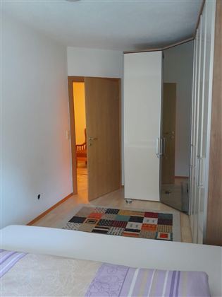 Gemütliches Schlafzimmer mit einem komfortablen Doppelbett, einem geräumigen Kleiderschrank und viel Stauraum für Ihre persönlichen Gegenstände. Die helle und einladende Atmosphäre sorgt für einen entspannten und angenehmen Aufenthalt.
