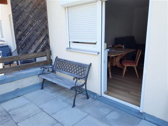Genieße entspannte Stunden auf deiner eigenen Terrasse mit gemütlicher Sitzbank. Ob Frühstück an der frischen Luft, ein Kaffee in der Morgensonne oder ein Glas Wein am Abend – hier kannst du die ruhige Atmosphäre genießen und den Alltag hinter dir lassen. Durch den direkten Zugang zum Wohnbereich ist die Terrasse der perfekte Ort, um drinnen und draußen harmonisch zu verbinden