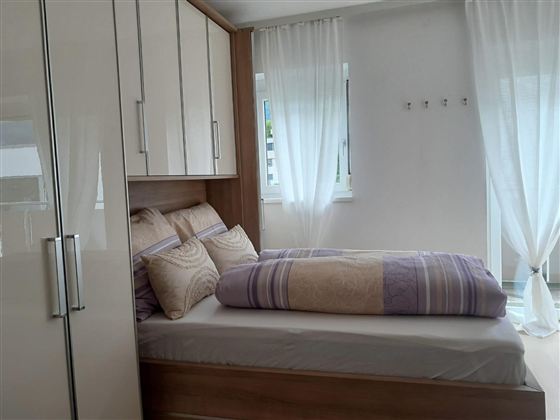Gemütliches Schlafzimmer mit einem komfortablen Doppelbett, einem geräumigen Kleiderschrank und viel Stauraum für Ihre persönlichen Gegenstände. Die helle und einladende Atmosphäre sorgt für einen entspannten und angenehmen Aufenthalt.