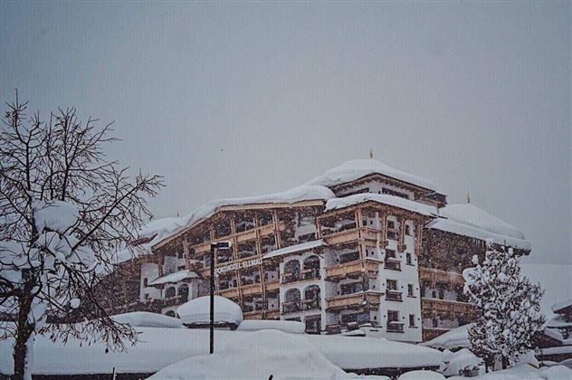 A large building in a snowy landscape. The winter snow covers roofs and trees.