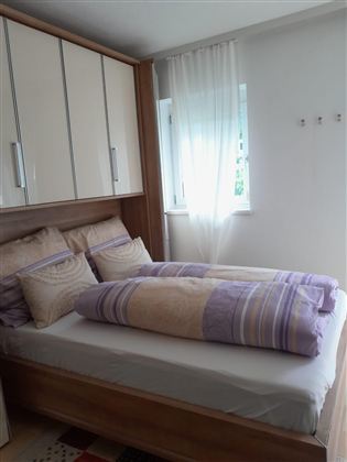 Gemütliches Schlafzimmer mit einem komfortablen Doppelbett, einem geräumigen Kleiderschrank und viel Stauraum für Ihre persönlichen Gegenstände. Die helle und einladende Atmosphäre sorgt für einen entspannten und angenehmen Aufenthalt.