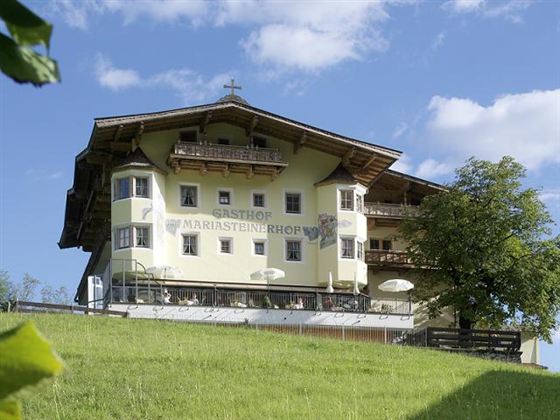 A beautiful house on a green meadow under a blue sky. Surrounded by trees, the scene radiates tranquility and idyll.