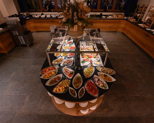 A buffet with a variety of dishes in elegant bowls. The selection includes fresh fruit, vegetables, and other delicacies.