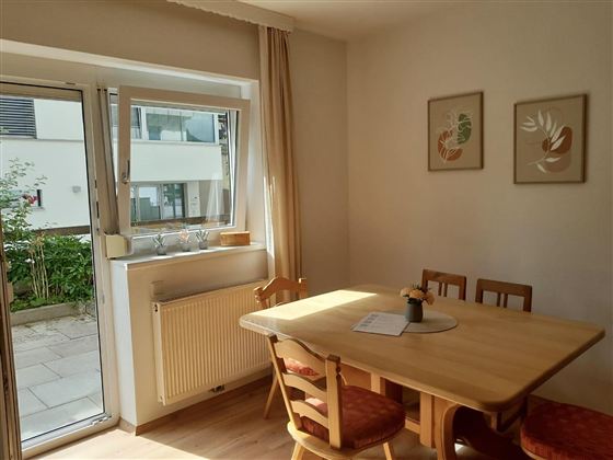 Das großzügige Wohn- und Esszimmer überzeugt mit viel Tageslicht, einer gemütlichen Atmosphäre und direktem Zugang zur Terrasse. Der Essbereich lädt zu gemeinsamen Mahlzeiten ein, während die großen Fenster einen schönen Blick ins Grüne bieten – der ideale Ort zum Entspannen und Wohlfühlen.