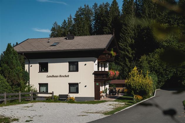 Ein charmantes Haus mit einem großen Garten, umgeben von Bäumen. Die zentrale Lage und die gepflegte Fassade laden zum Entspannen ein.