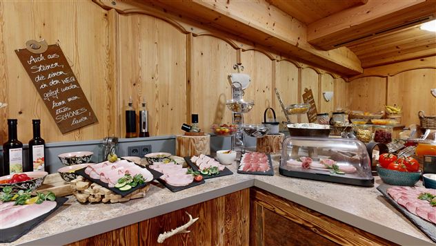 A buffet with various types of meat and fresh ingredients in a rustic setting. The wood look creates a cozy atmosphere.