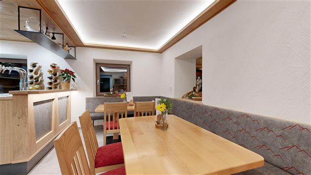 A cozy restaurant with wooden tables and benches. The soft lighting creates an inviting atmosphere.