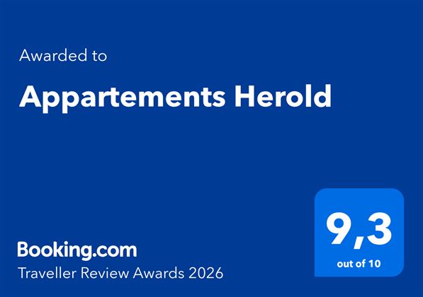 Das Bild zeigt eine Auszeichnung von Booking.com für die Appartements Herold mit einer Bewertung von 9,3 von 10. Es handelt sich um die Traveller Review Awards 2026.