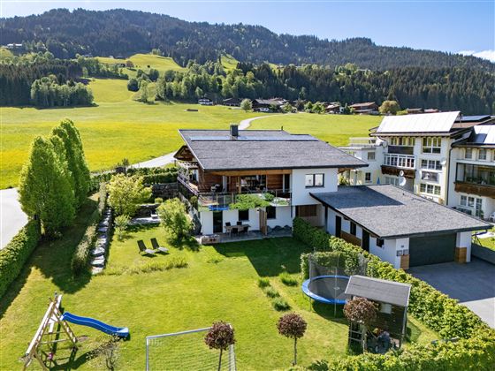 A beautiful house in a quiet environment, surrounded by green meadows and mountains. The garden has a swing and a trampoline.