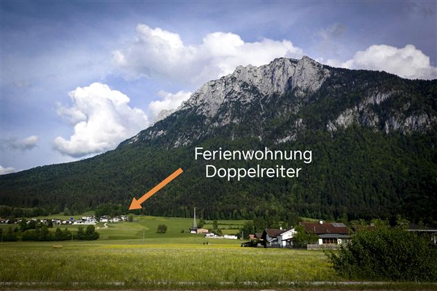 Eine malerische Landschaft mit Bergen und Wiesen. Es zeigt die Ferienwohnung Doppelreiter in der Nähe eines ruhigen Dorfes.