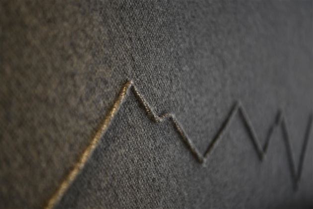 A gray fabric with a uniform, ascending line graphic. The lines resemble a diagram or a statistical representation.