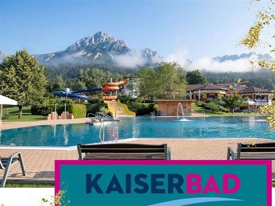 A beautiful pool with a view of the mountains and plenty of greenery. In the background, there are water slides and an inviting recreational area.