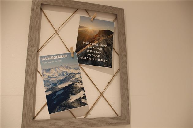 Ein Bilderrahmen mit zwei Postern. Das linke Poster zeigt die Kaisergebirge, das rechte ermutigt, die Schönheit der Natur zu genießen.