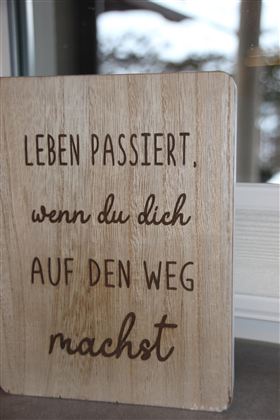 Ein Holzschild mit inspirierendem Spruch. Der Text ermutigt dazu, aktiv zu werden und den eigenen Weg zu gehen.