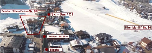 An aerial view of a ski resort with labeled points. Visible are buildings, a church, and ski slopes in the snow.