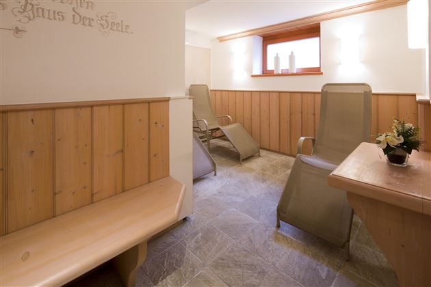 Ein ruhiger Wellnessbereich mit Holzverkleidung und bequemen Liegen. Sanftes Licht und eine entspannende Atmosphäre laden zur Erholung ein.