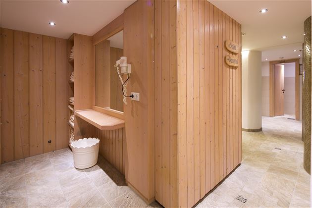 Ein entspannender Wellnessbereich mit Holzverkleidung und sanfter Beleuchtung. Der Raum hat eine ruhige Atmosphäre und ist gut gestaltet für Erholung.