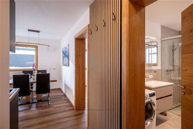 Een kleine gang met een moderne garderobe.