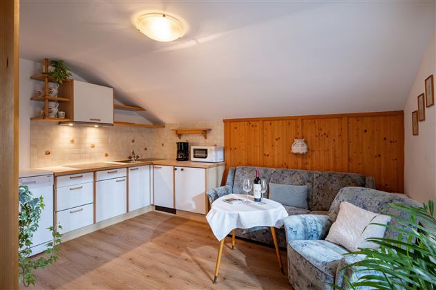 A cozy apartment with a modern kitchen and a living room area. A small table with two armchairs invites you to linger.