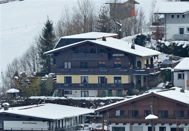 A picturesque building in the snow with a traditional alpine style. Surrounded by trees and a tranquil winter landscape.
